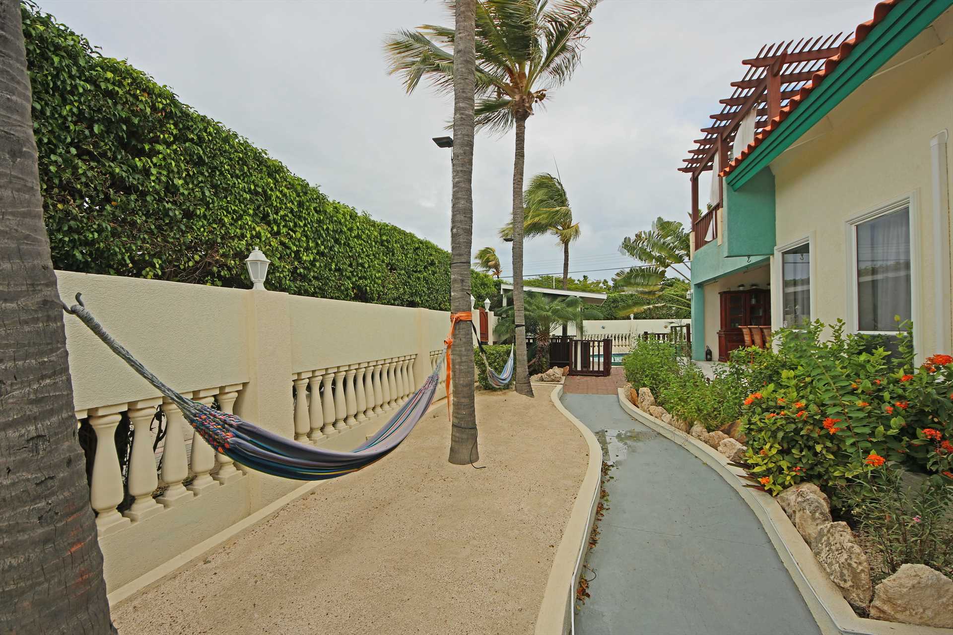 Front yard of the Palm Beach Fortress with 2 hammocks to rel