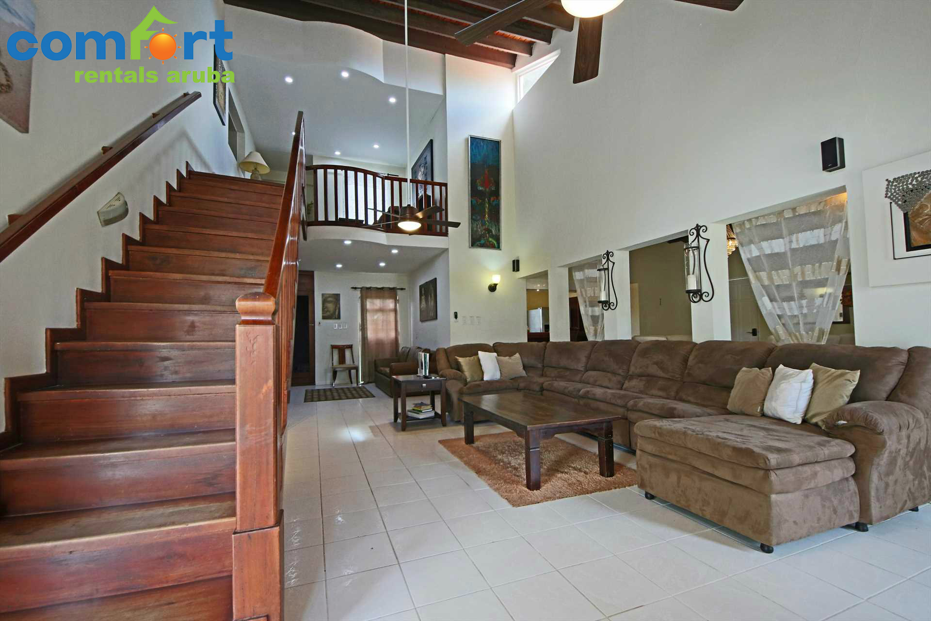 Spacious semi-open living room and stairs leading to the master bedroom